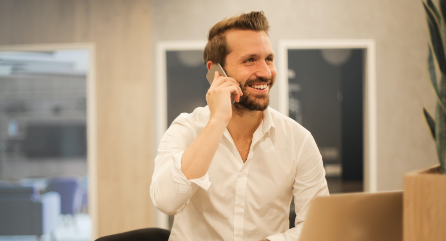 man smiling on phone in office