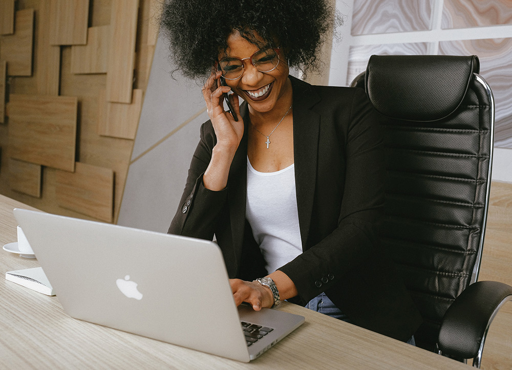 Businesswoman talking on phone and using laptop