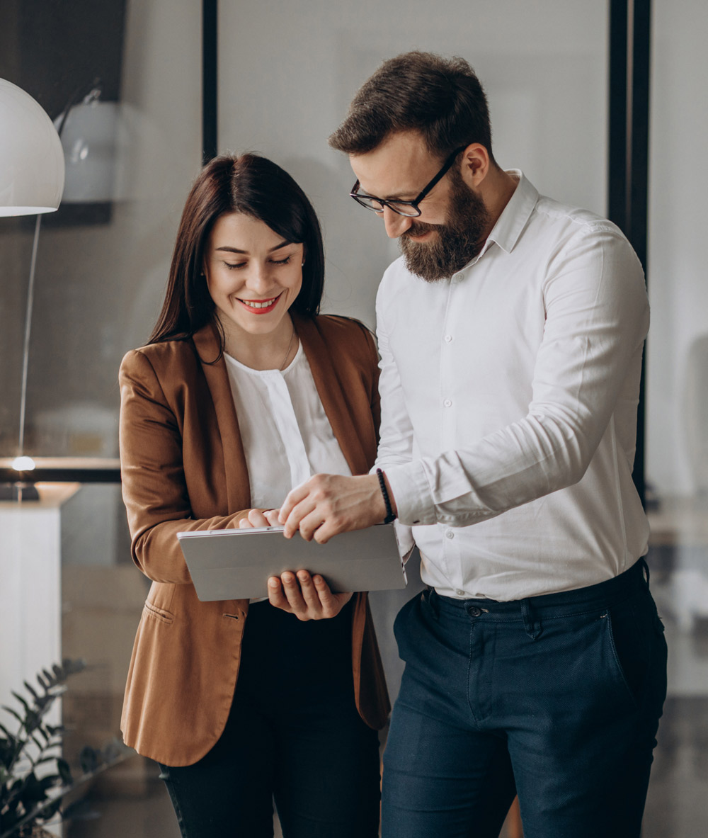 man and woman looking at a tablet in an office