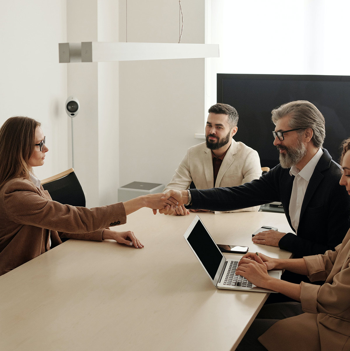 Office employees at table shaking hands